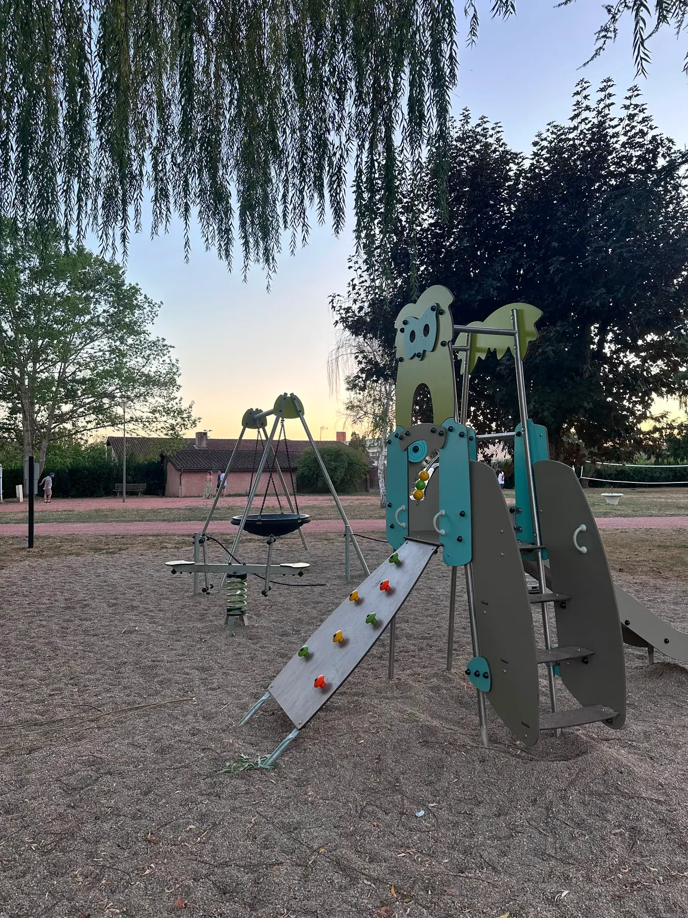 Parc de Charlieu — L’aire de jeux au soleil couchant, sous le saule