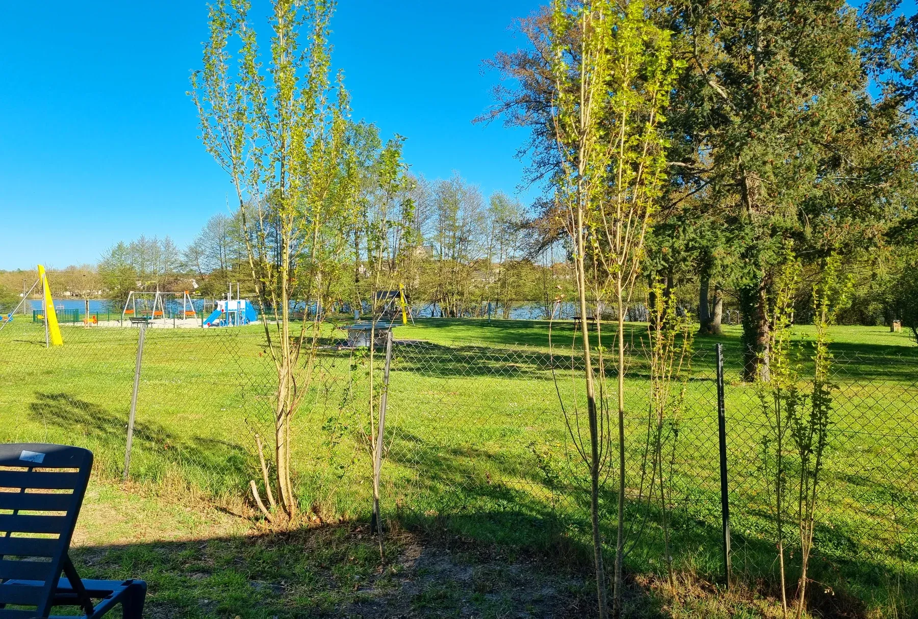 Parc de Coullons Grand Parc — L’aire de jeux et l’étang, vus depuis une parcelle