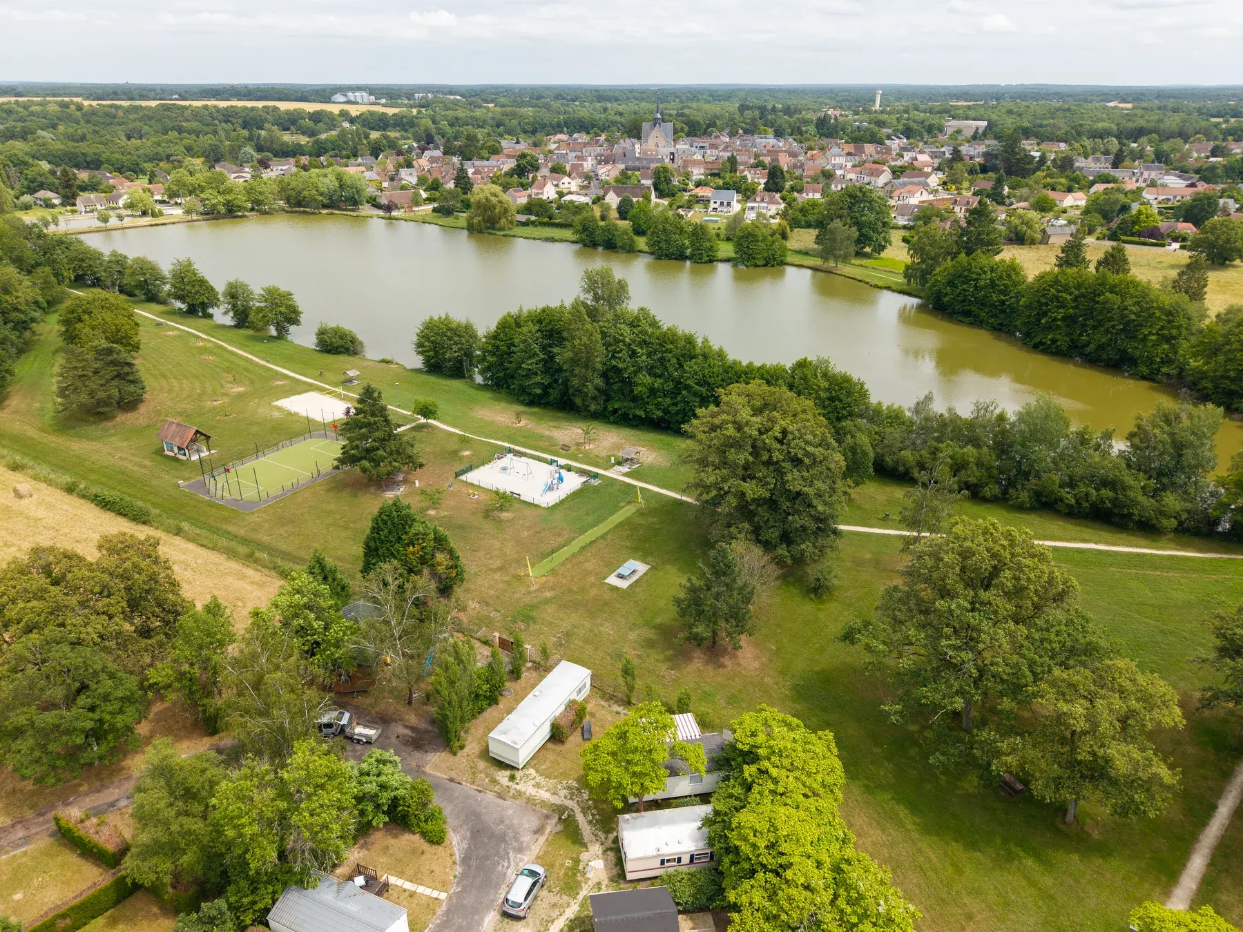 Parc de Coullons Grand Parc — L’étang, l’aire de jeux et le terrain multisport en bordure du parc