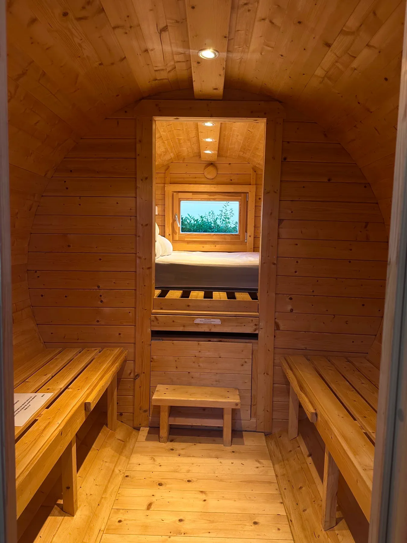 Parc de Charlieu — L’intérieur d’un tonneau : les banquettes à l’entrée, le couchage au fond